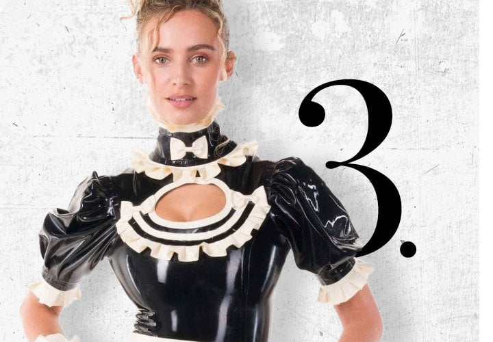 Imogen wearing the Westward Bound Imogen Frilled Keyhole Latex Leotard in black with contrasting warm white frills